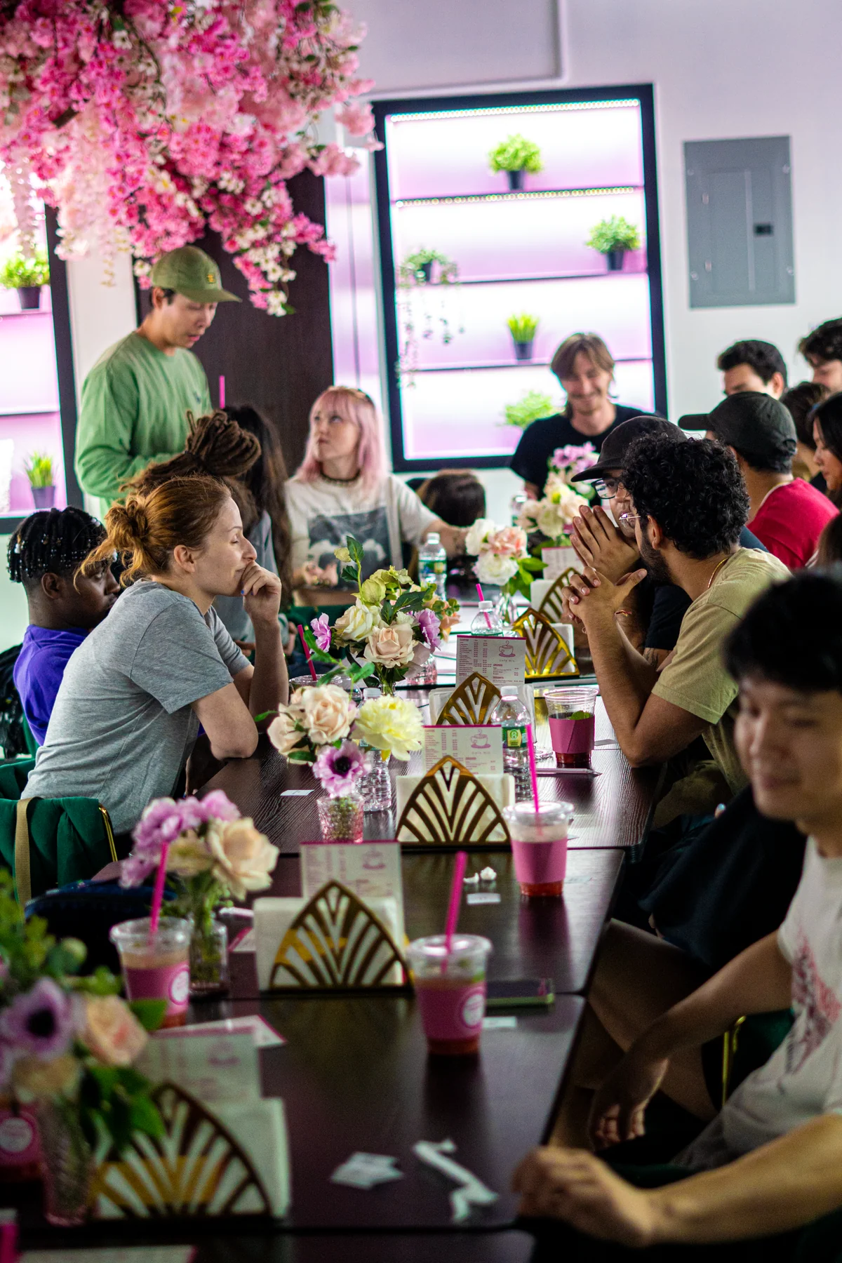 Volunteers filling Café Mia's dining room after the Bushwick community cleanup, sharing matcha and food at long tables with fresh flowers