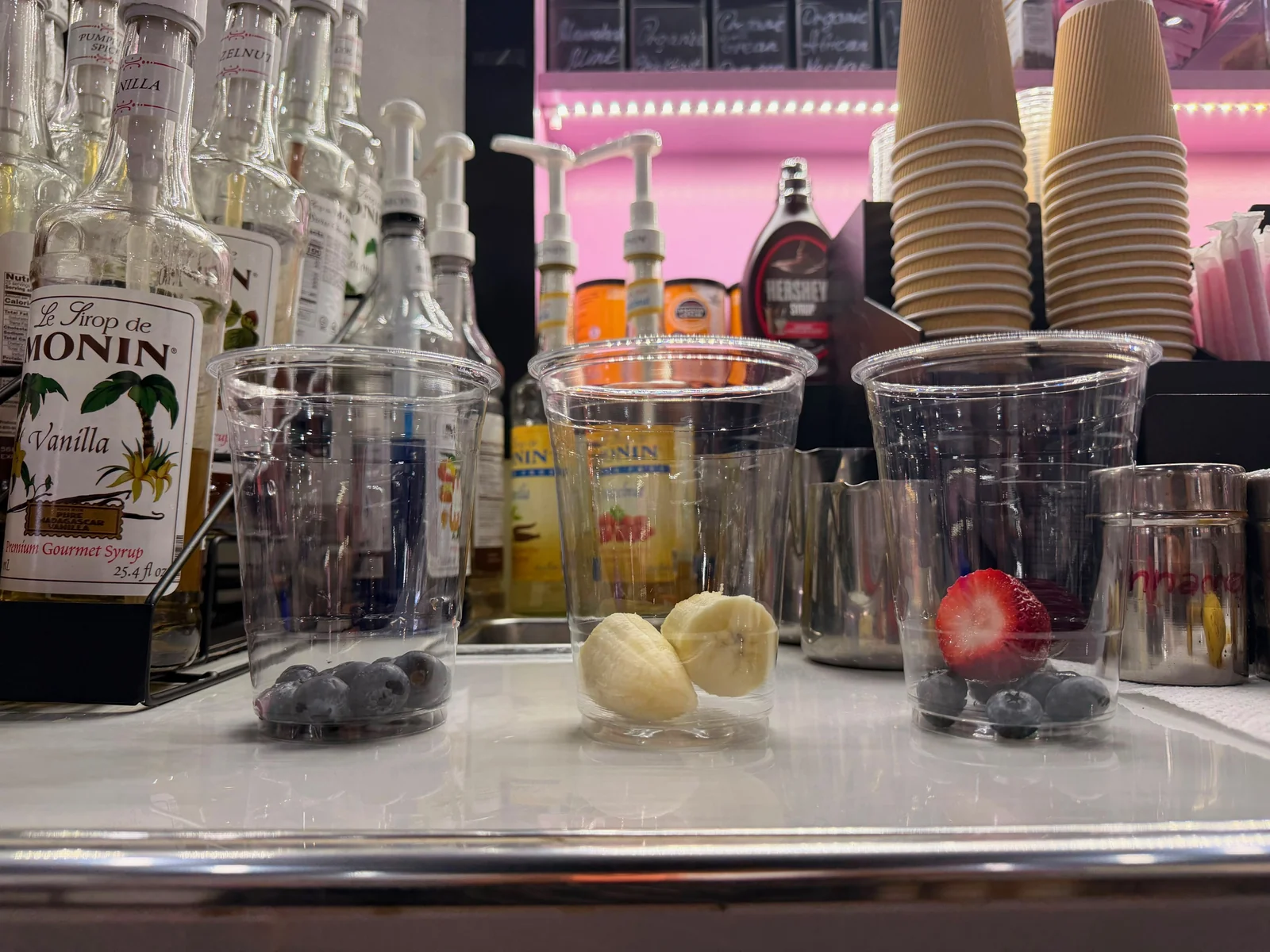 Fresh strawberry and blueberries at the base of the cup — the start of Pink Matcha Dragonfruit at Café Mia